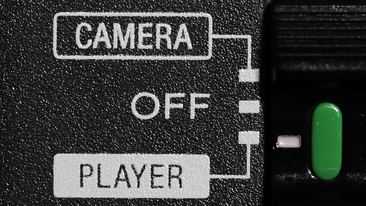 Close up of green camcorder mode switch moving from camera to player and back