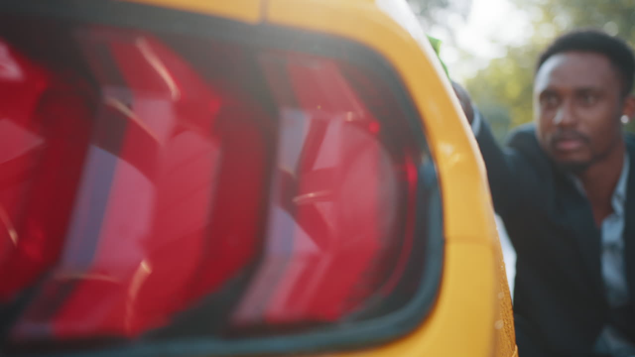 hombre lavando un coche amarillo