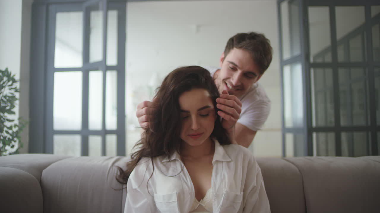 hombre se acerca a la mujer mientras trabaja en casa