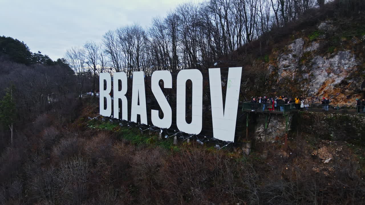 Brasov sign on the top of the hill near the city, bare trees, tourists, Romania