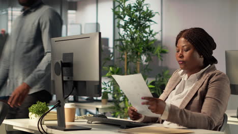 african american businesswoman reviewing documents in modern office