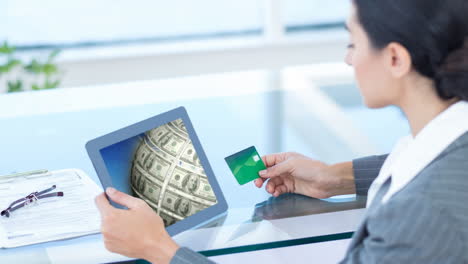 holding tablet displaying money animation, woman using credit card