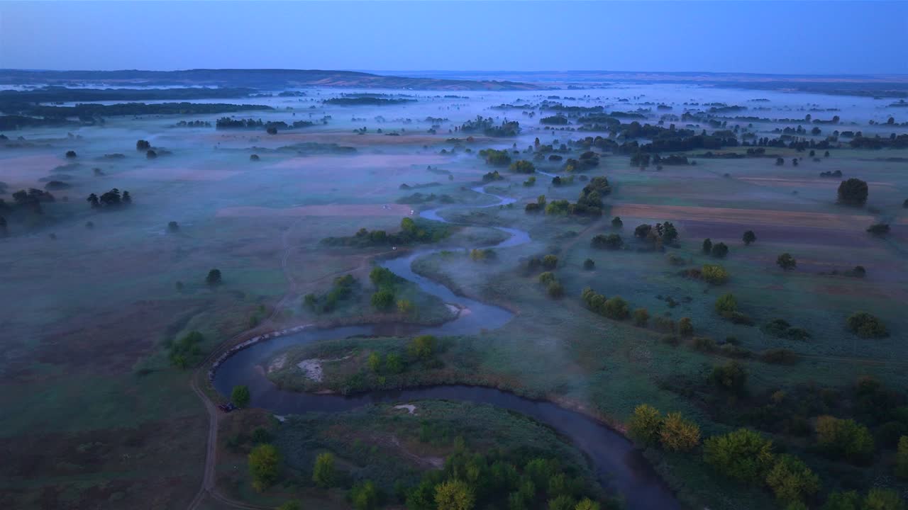 Aerial view over misty Nida river at blue hour in Poland, serene landscape