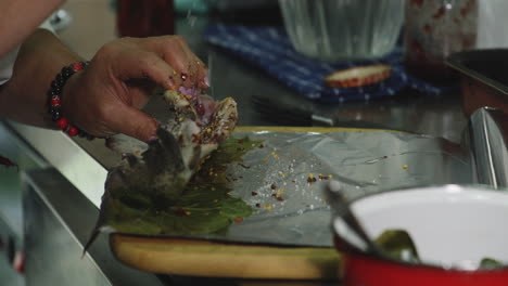 Salting-filleted-raw-trout-before-wrapping-it-in-baking-tin-foil