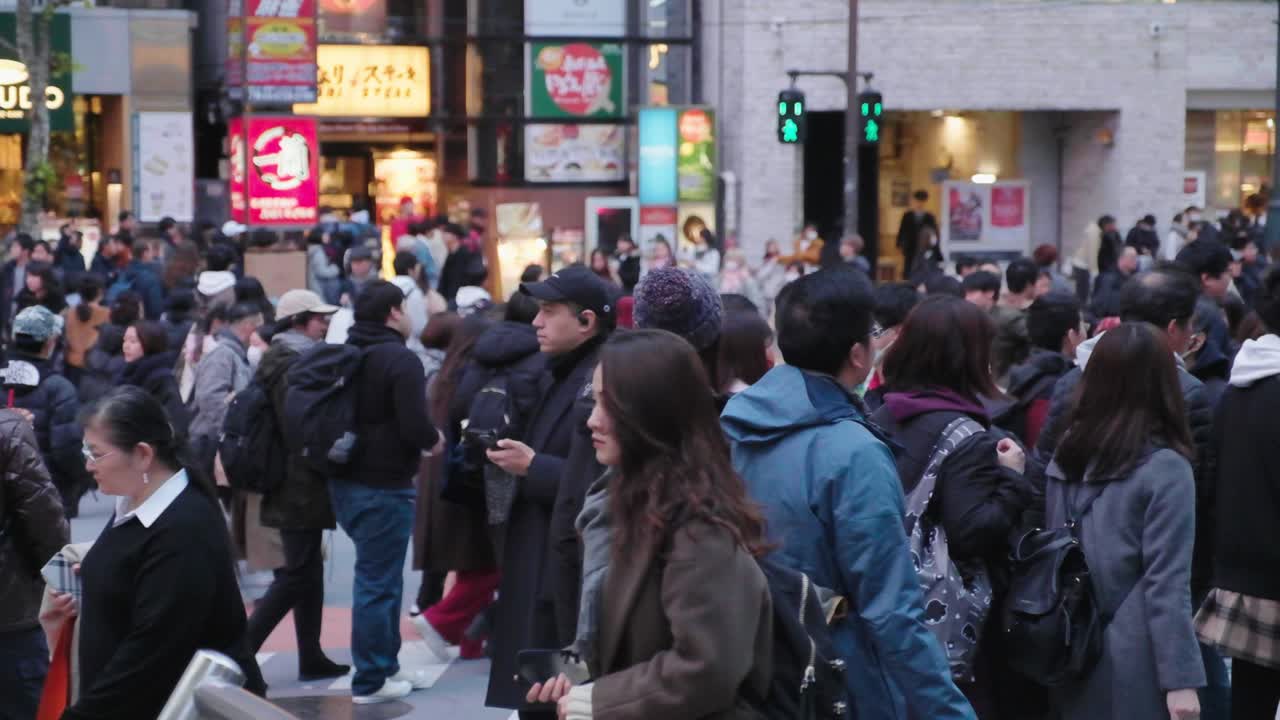People crossing a busy intersection in downtown Tokyo, Japan. Slow motion