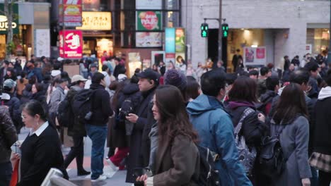 people crossing a busy intersection in downtown tokyo, japan. slow motion
