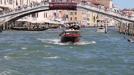 venice ponte degli scalzi: small boat cruising under bridge in slow motion venice italy