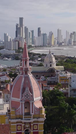 aerial view of cartagena's colonial architecture and modern bocagrande skyline, showcasing the cathedral santa catalina de alejandria and the caribbean sea. vertical video