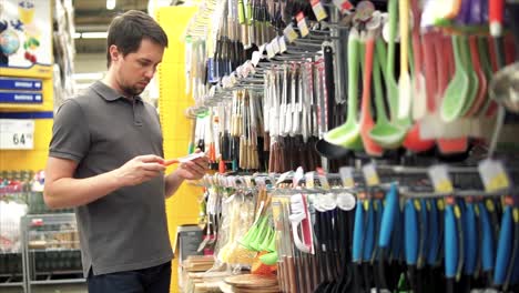 hombre comprando utensilios de cocina en una tienda de comestibles
