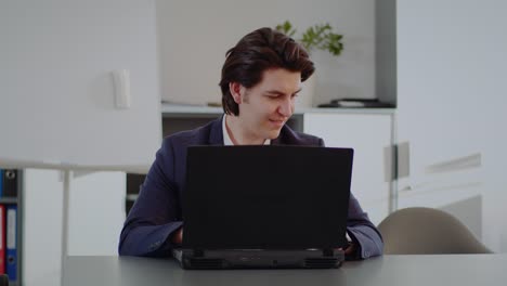 hombre positivo en la oficina trabajando en una computadora portátil
