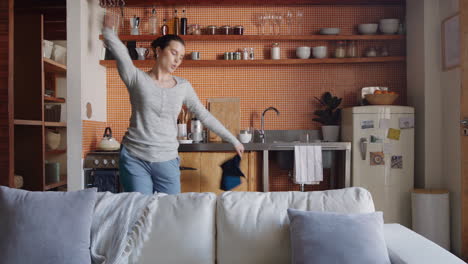 Una-Joven-Feliz-Bailando-En-La-Cocina-Celebrando-Un-Estilo-De-Vida-Exitoso-Disfrutando-De-Una-Alegre-Celebración-Del-Baile-De-La-Victoria-En-Casa-El-Fin-De-Semana