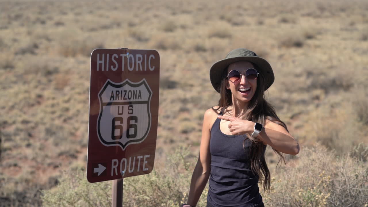 mujer joven posando junto a la histórica ruta 66 firmar en arizona usa, fotograma completo