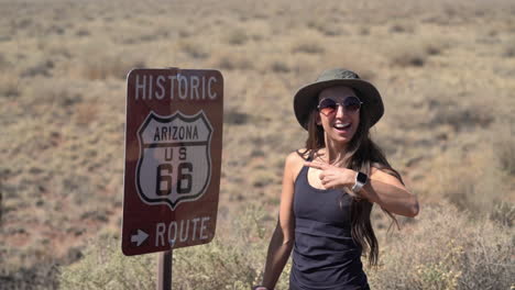 mujer joven posando junto a la histórica ruta 66 firmar en arizona usa, fotograma completo