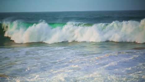 dangerous ocean waves foaming on summer morning. huge surf rolling to shallow