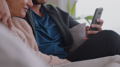 happy-couple-relaxing-at-home-using-smartphone-together-shopping-online-enjoying-browsing-internet-relaxing-on-couch