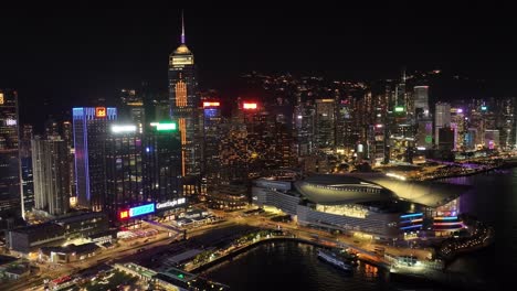 aerial pan shot of downtown city in hong kong with tall skyscrapers. nighttime.