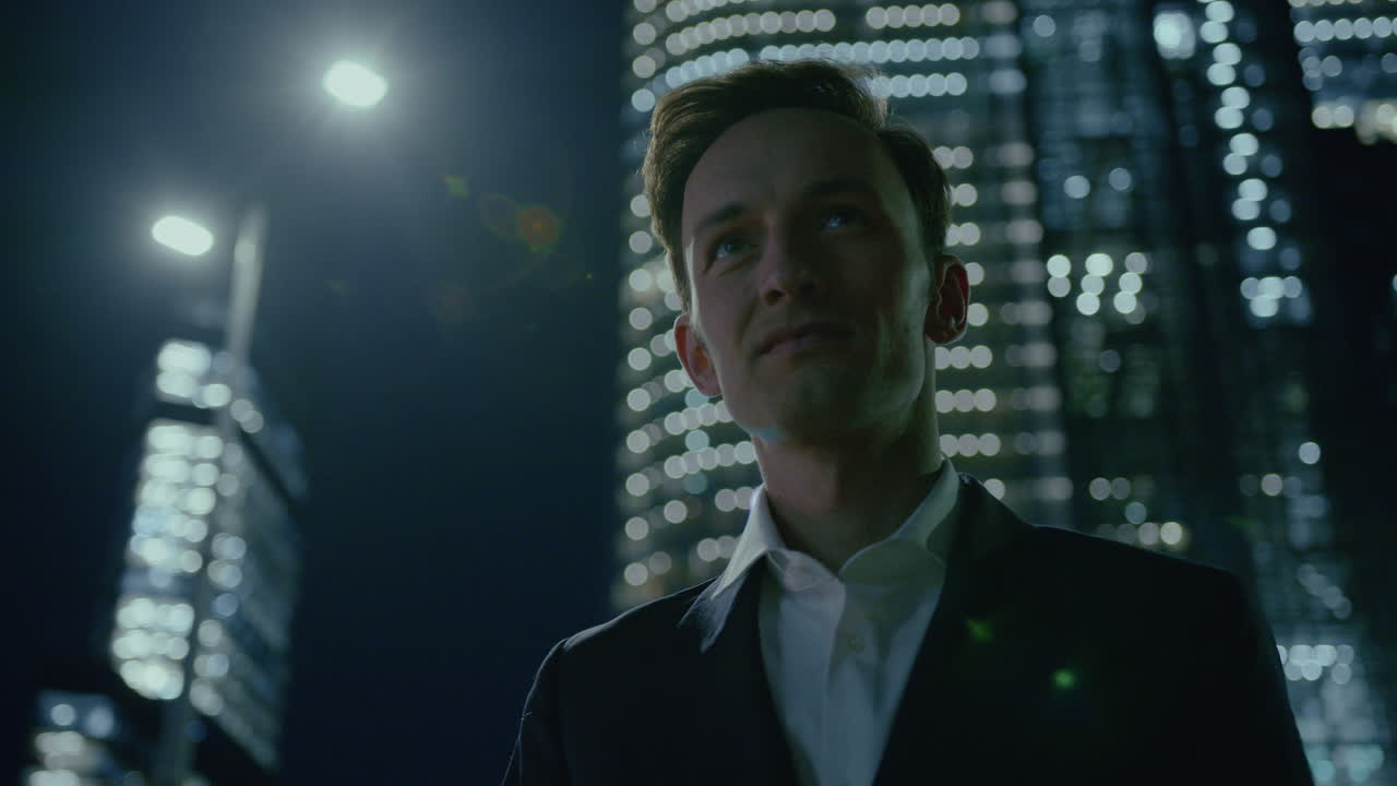 un hombre feliz y exitoso sonriendo tímidamente mientras ella sale de la oficina por la noche