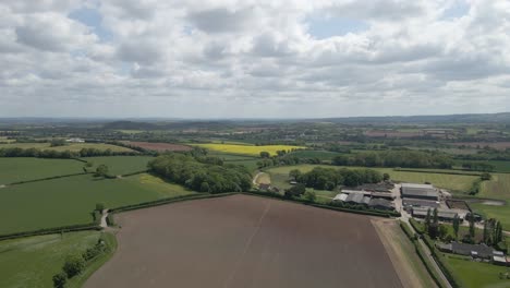 arial view of stogursey parish in the quantock hills somerset. drone moving forward over the fields and in direction to the quantock hills.