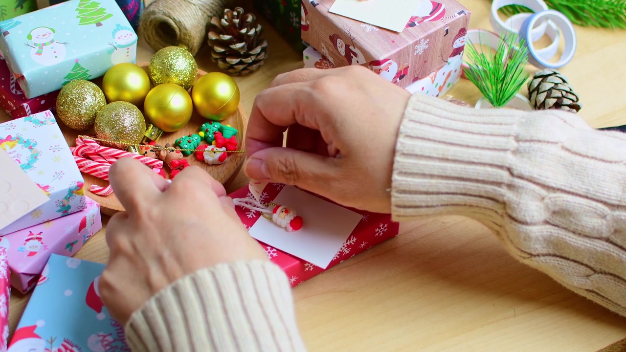 Mani di donna che decorano una confezione regalo di Natale