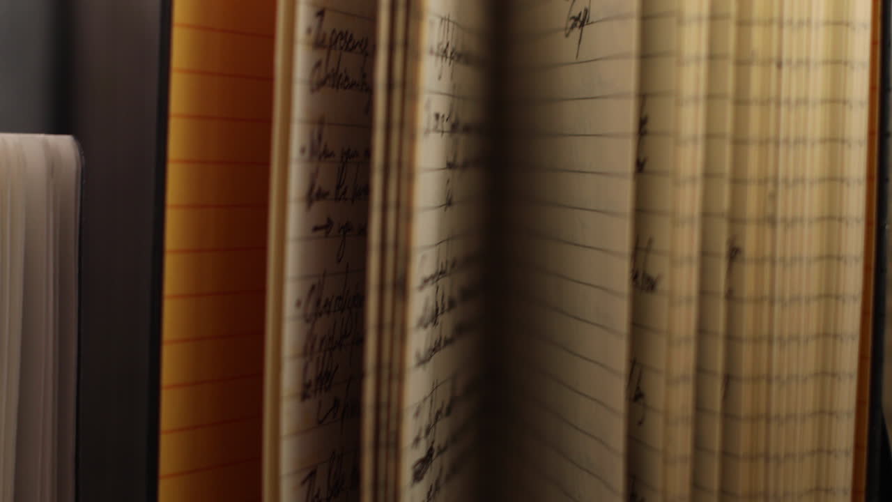 Handheld shot moves away from upright old notebooks