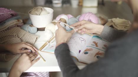 woman learning to knit using book with knitting pattern. knitting hands