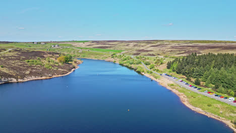 immerse yourself in the scenic beauty of winscar reservoir in yorkshire, where sailing club members engage in a spirited boat race, their white sails creating a mesmerizing sight