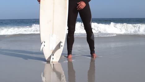 man in wet suit raising arms