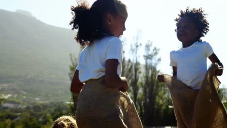 children playing a sack race in park