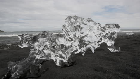 diamond beach iceland - a large natural ice sculpture sits on the black volcanic beach and glistens like a diamond