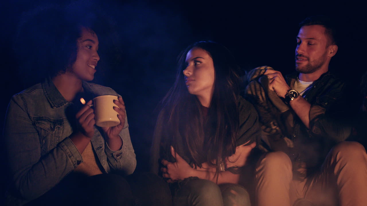 parejas acurrucadas junto a la fogata disfrutando