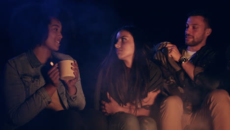 parejas acurrucadas junto a la fogata disfrutando