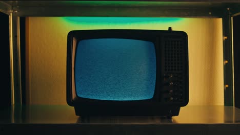 a retro tv displaying static noise, creating a nostalgic vintage atmosphere with blue and green hues.