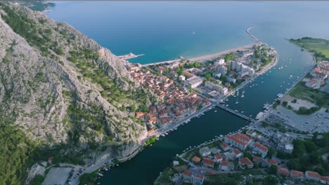 aerial view of omis town and port with cetina river meets the adriatic sea