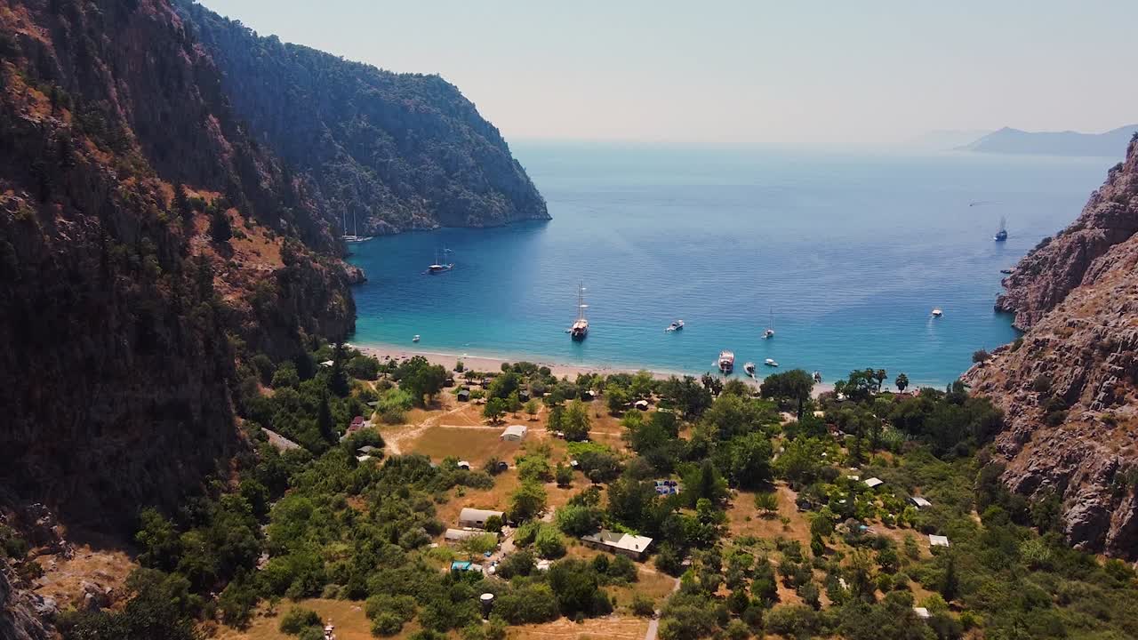 Aerial dolly shot of green trees and paradisiacal beach during sunny day