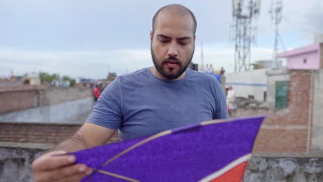 hombre indio comprobando la cometa