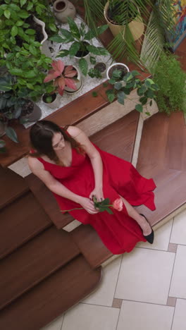 woman in scarlet gown and artist at easel. portraitist draws attractive lady with flower holding color palette in gallery. art creating inspiring process