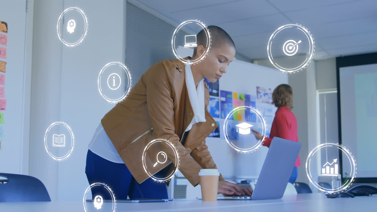 Animation of network of connections with icons over biracial businesswoman using laptop