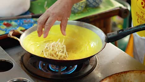 preparing pad thai with eggs and ingredients