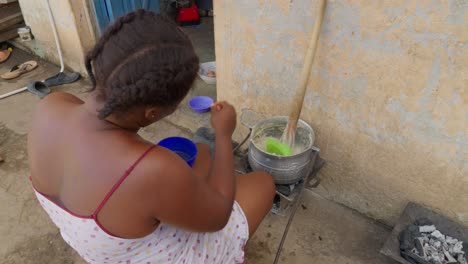una mezcla de banku preparada en una olla, empaquetada por una mujer ghanesa