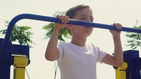 a little boy does sports on the playground 02