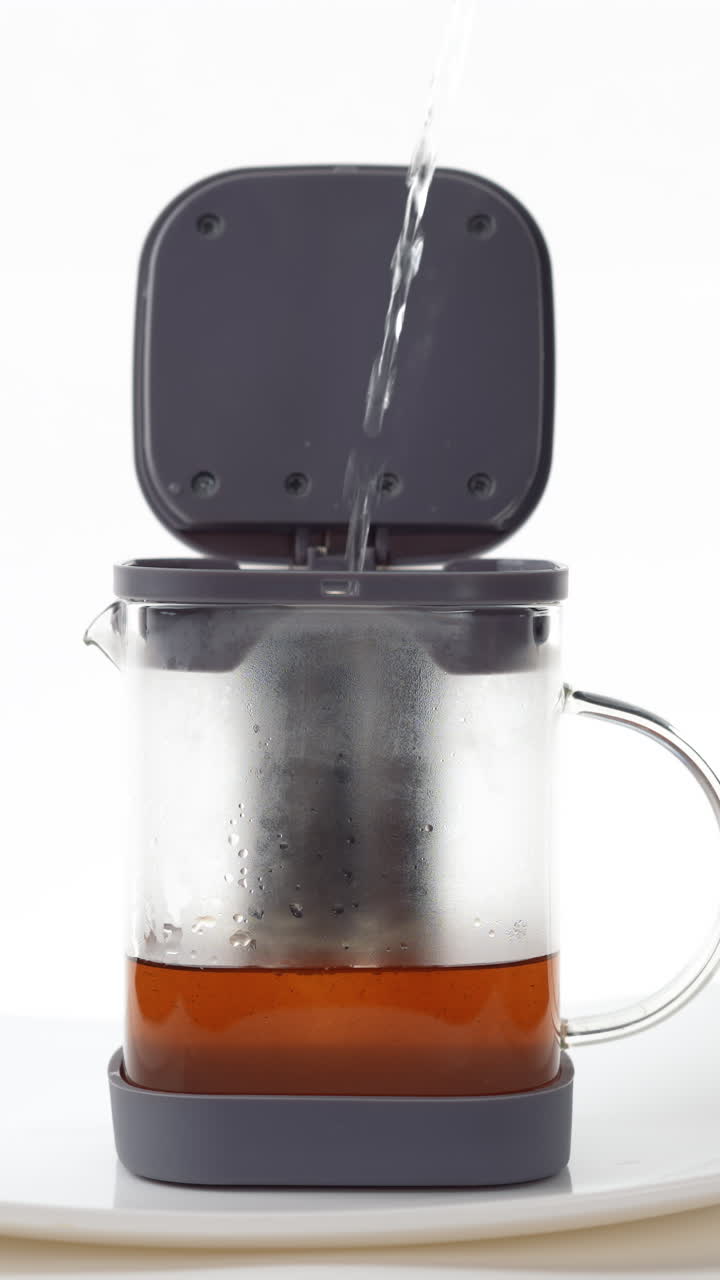 A hand Pouring hot water into a French press coffee maker on a white background