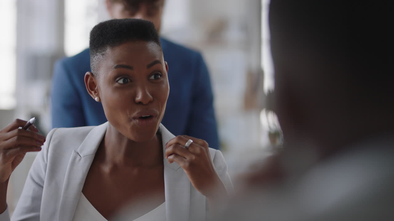 young african american business woman chatting with colleagues in office meeting having conversation sharing ideas in corporate workplace