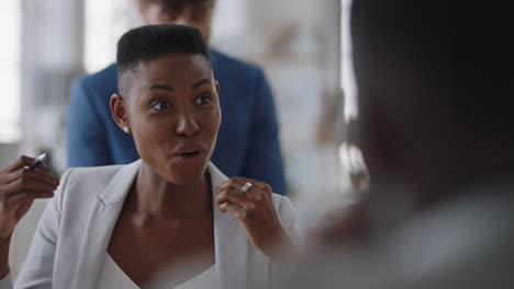 joven mujer de negocios afroamericana charlando con colegas en la oficina reunión teniendo conversación compartiendo ideas en el lugar de trabajo corporativo
