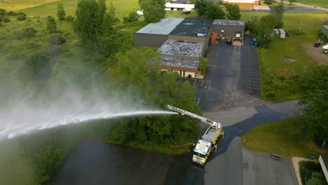 drone shot of a firetruck with a fully extended ladder spraying water as part of a training exercise