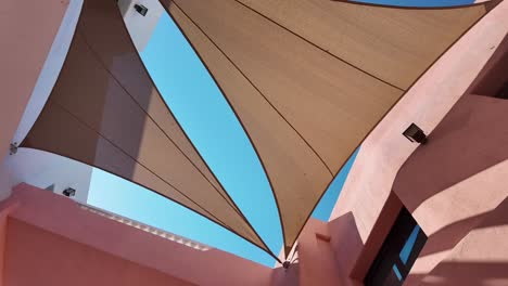 geometric shade sails against a bright blue sky