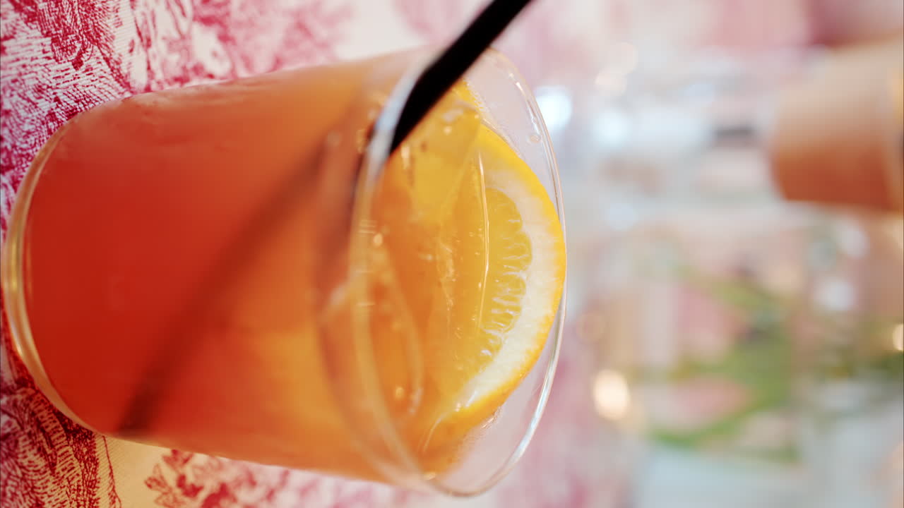 Primo piano di un cocktail arancione su un tavolo in un ristorante. Verticale
