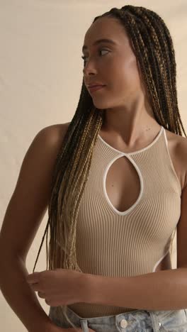 studio portrait shot of young woman with long braided hair feeling softness after hair care product