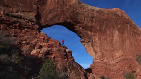 Ein-Wanderer-Steht-Auf-Einem-Felsvorsprung-Im-Arches-National-Park-Utah