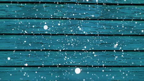 Animation-of-snow-falling-over-blue-wooden-surface