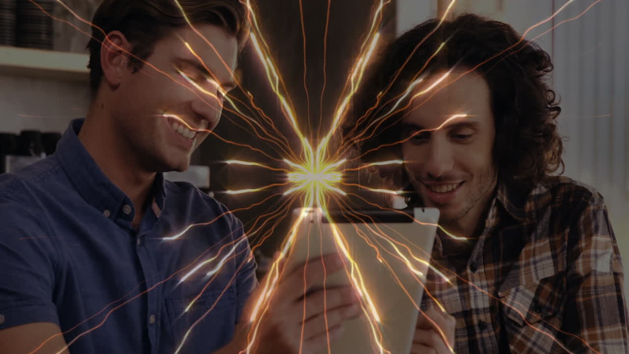 Two people looking at tablet with dynamic energy burst animation overlay
